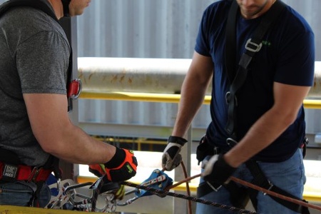 Two rescuers prepare rigging for technical rescue team training